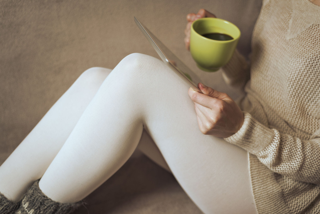 A woman sip a mug of coffee