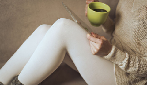 A woman sip a mug of coffee